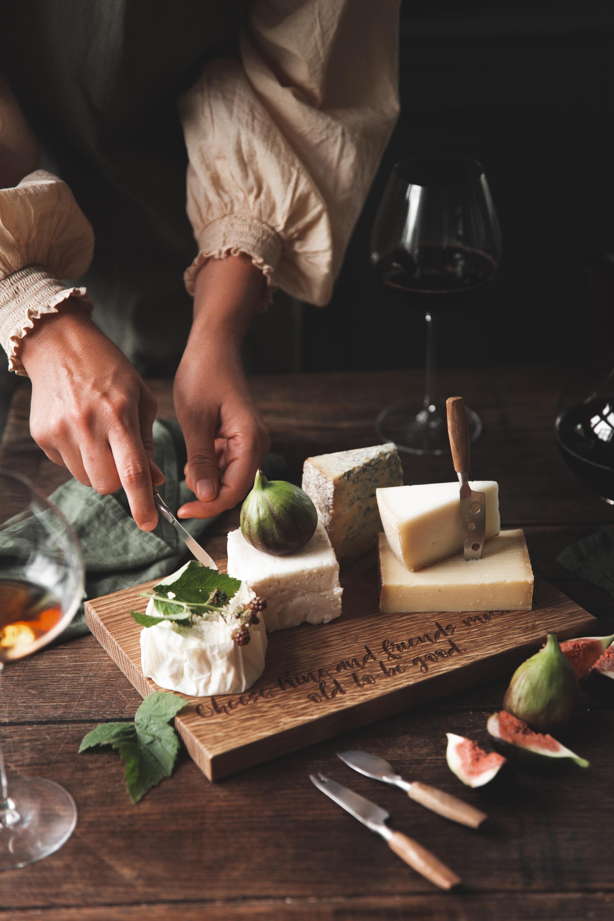 En person tar en bit ost från en ostbricka