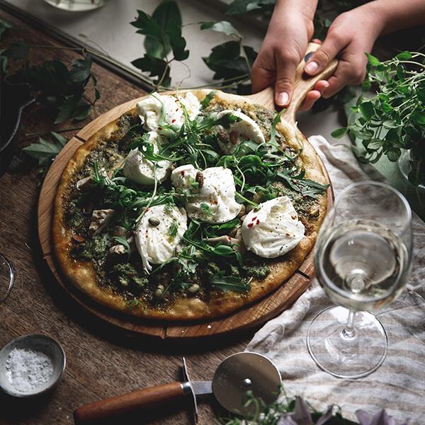 Pizza med ruccola, pesto och pinjenötter