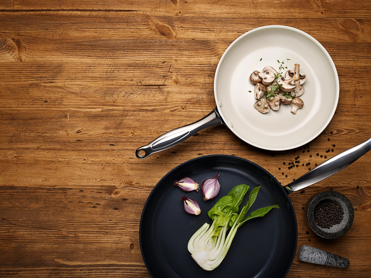 Keraaminen paistinpannu vihannesten kera puisella keittiön työtasolla