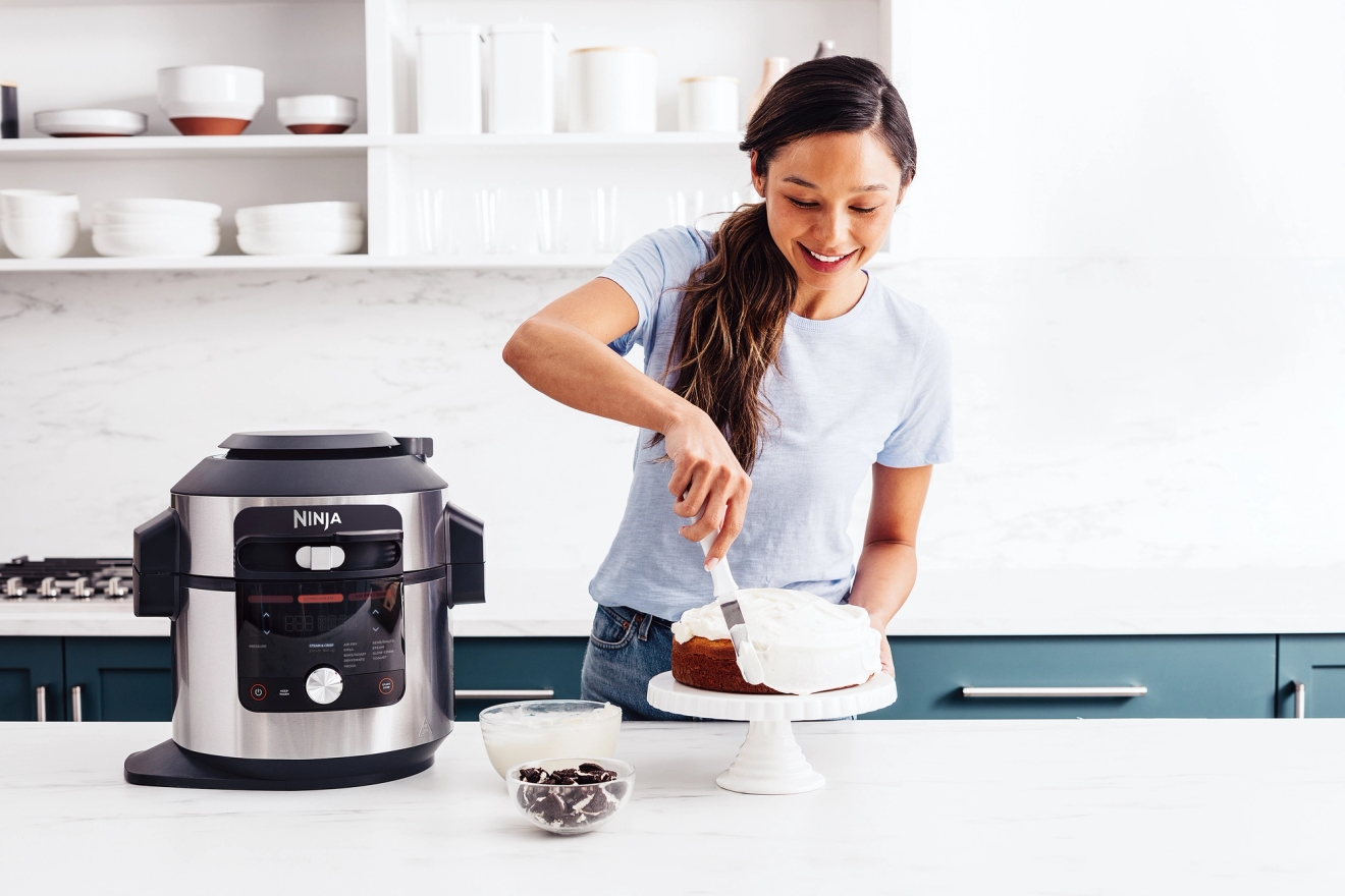 Ninja airfryer på köksbänk med en tårta på ett tårtfat
