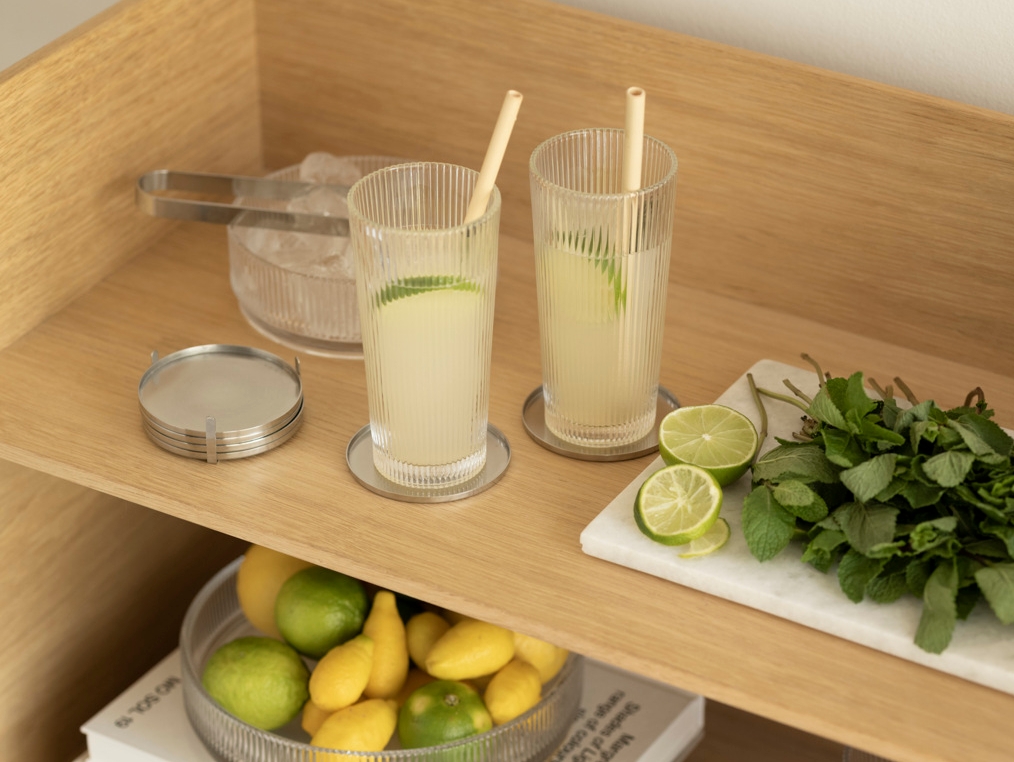 Två glas lemonad med lime och mynta står på en stilren drinkvagn i trä.