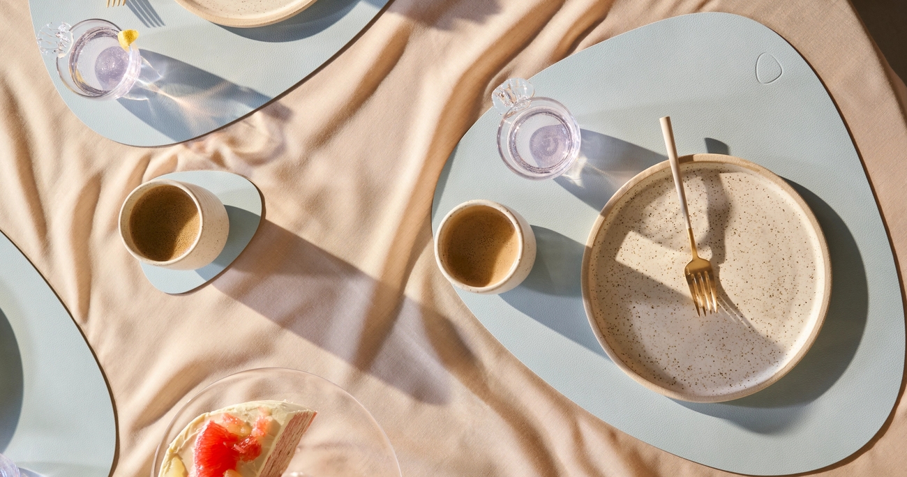 Pöytätabletit ja lasinaluset värissä vaaleansininen katetulla pöydällä