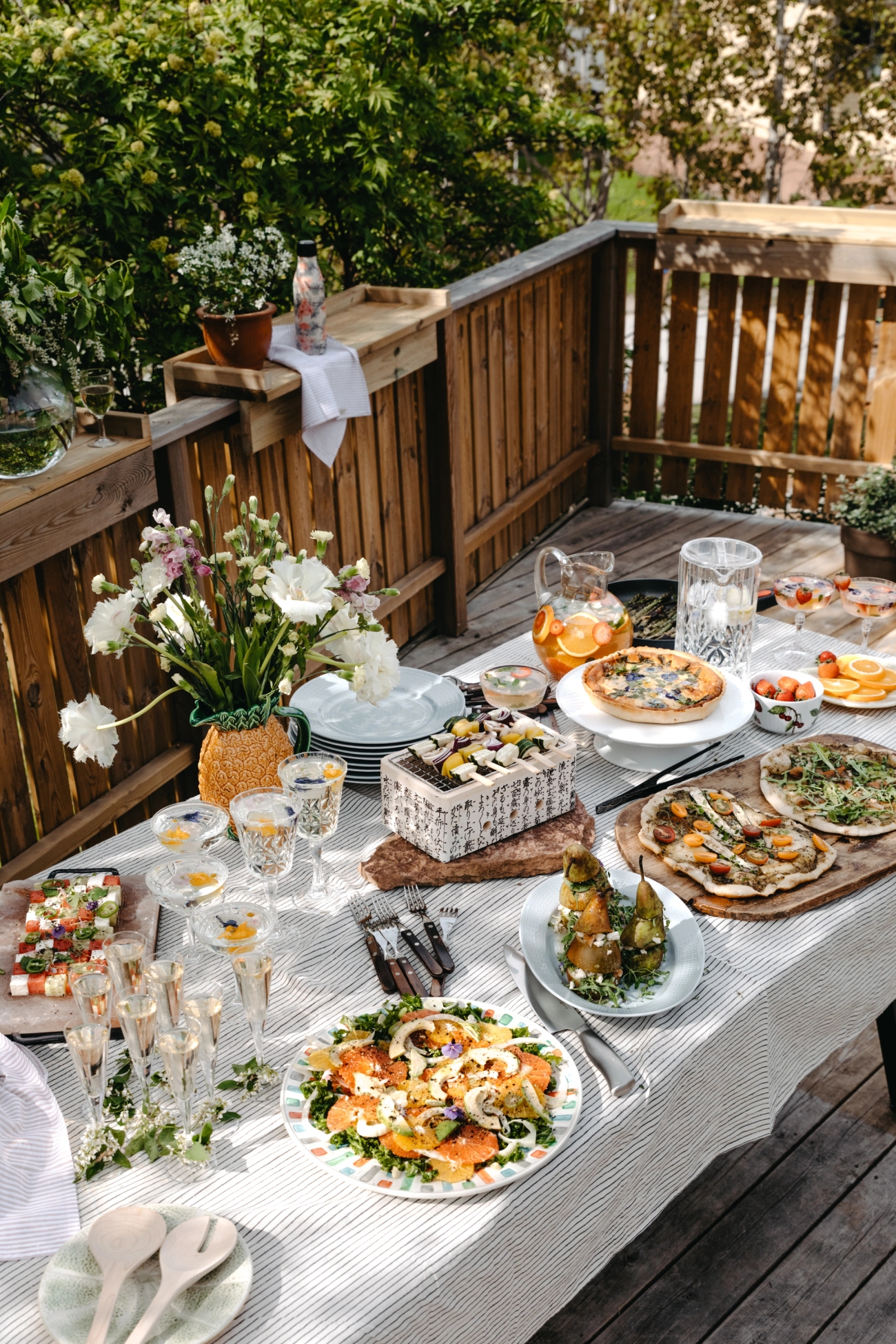 Kesä illallinen pöydän kattaus juomalasit, cocktaillasit, lautaset, tarjoiluastiat