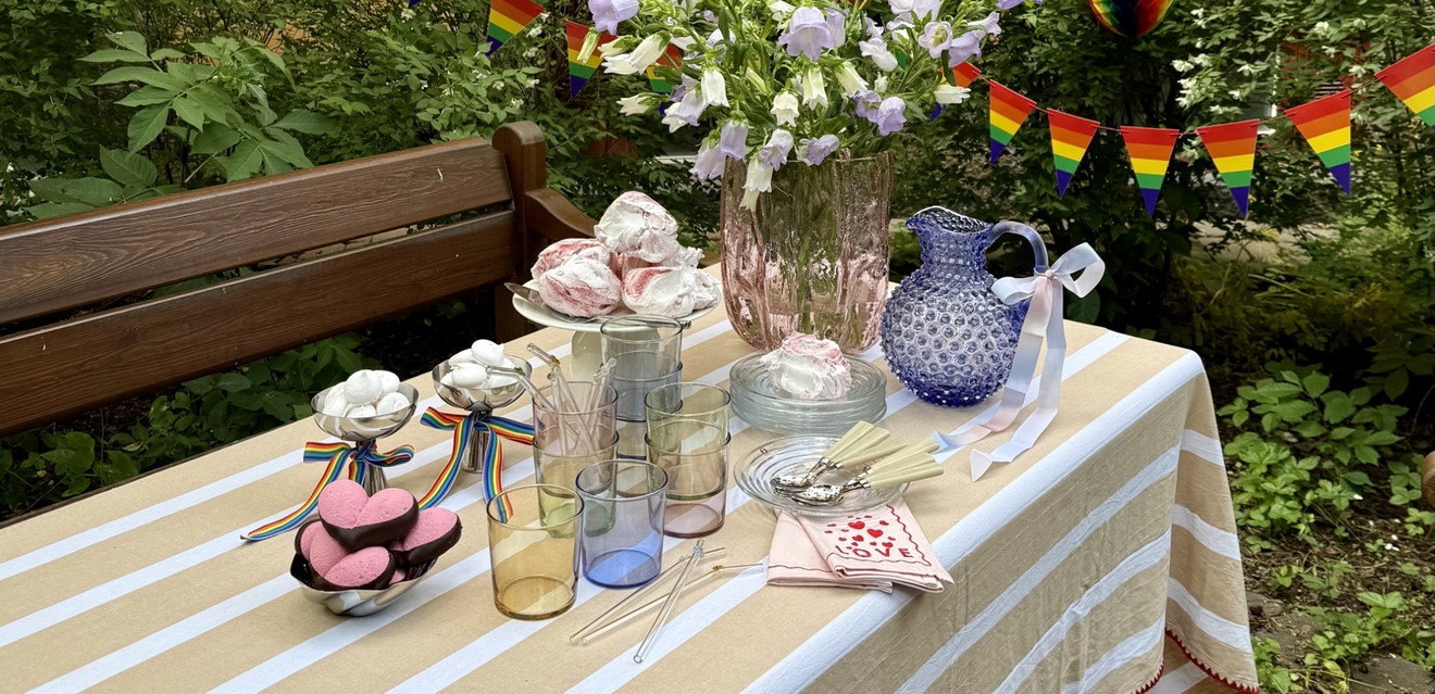 a table with a striped tablecloth and a vase of flowers on it .