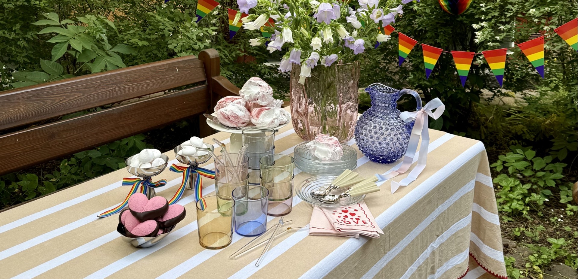 a table with a striped tablecloth and a vase of flowers on it .
