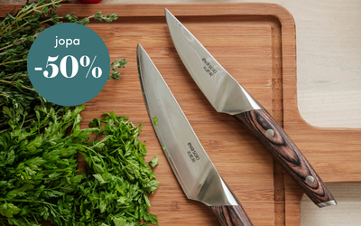 Keittiöveitset ja tuoreet yrtit leikkuulaudalla, tarjousteksti jopa -50 %.