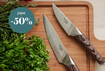 Kaksi keittiöveistä ja tuoreita yrttejä puuleikkuulaudalla, kuvassa teksti 'jopa -50 %' tarjouksesta.