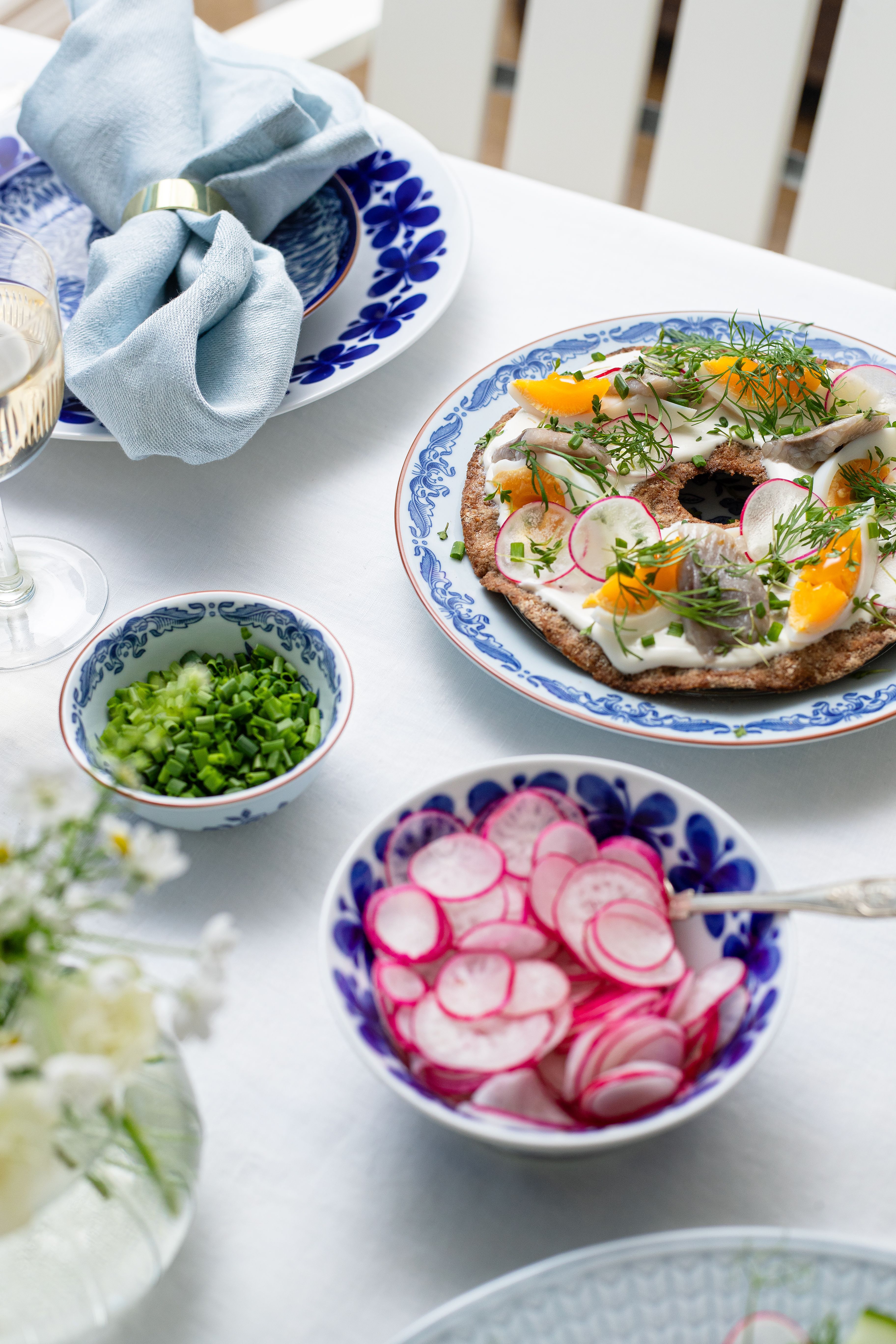 Knäckebröd med vackert upplagd sill, kokt ägg, rädisor och dill på en tallrik