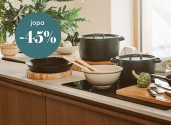 Tyylikkäästi katettu keittiötaso, jossa on mustia kattiloita, paistinpannu ja leikkuulaudat, sekä teksti jopa -45 % alennus.