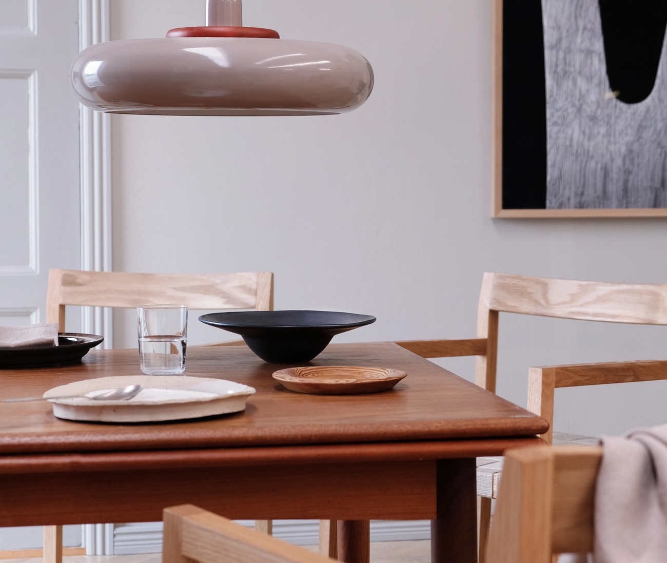 Matplats med bord och stolar i mörkt trä som är dukat med trenigt porslin