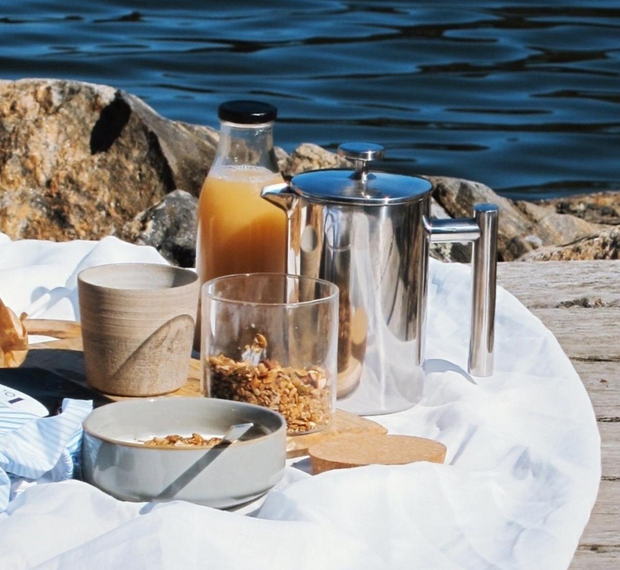 Aamiainen ulkona aamupala piknik granola pressopannu kahvi aamukahvi lautaset kulhot astiat