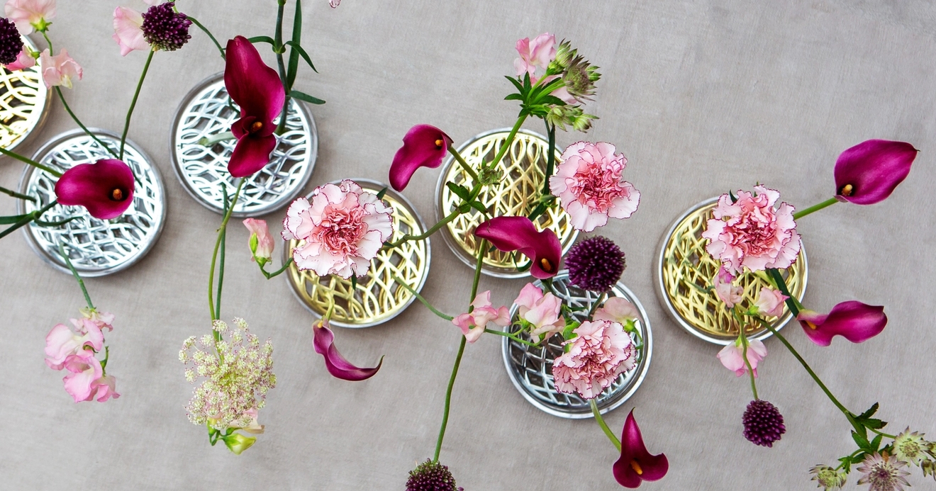 Klongin vaaleanpunaisia ja violetteja kukkia messingistä ja hopeisista maljakoista