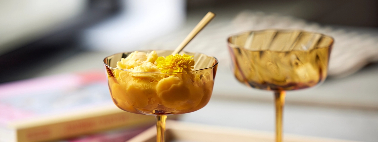 Keltaiset jälkiruokalasti jossa jäätelöä