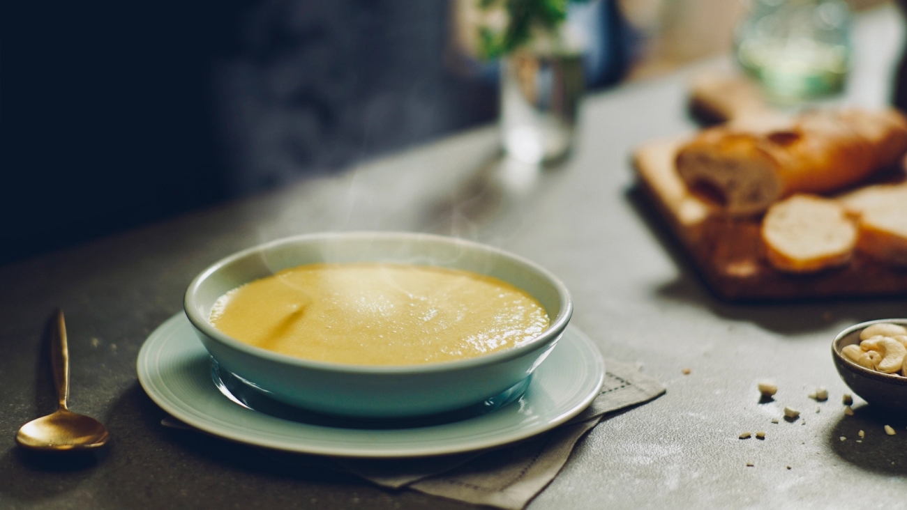Soppskålar i grå vit nyans med potatis och purjolökssoppa samt bröd vid sidan