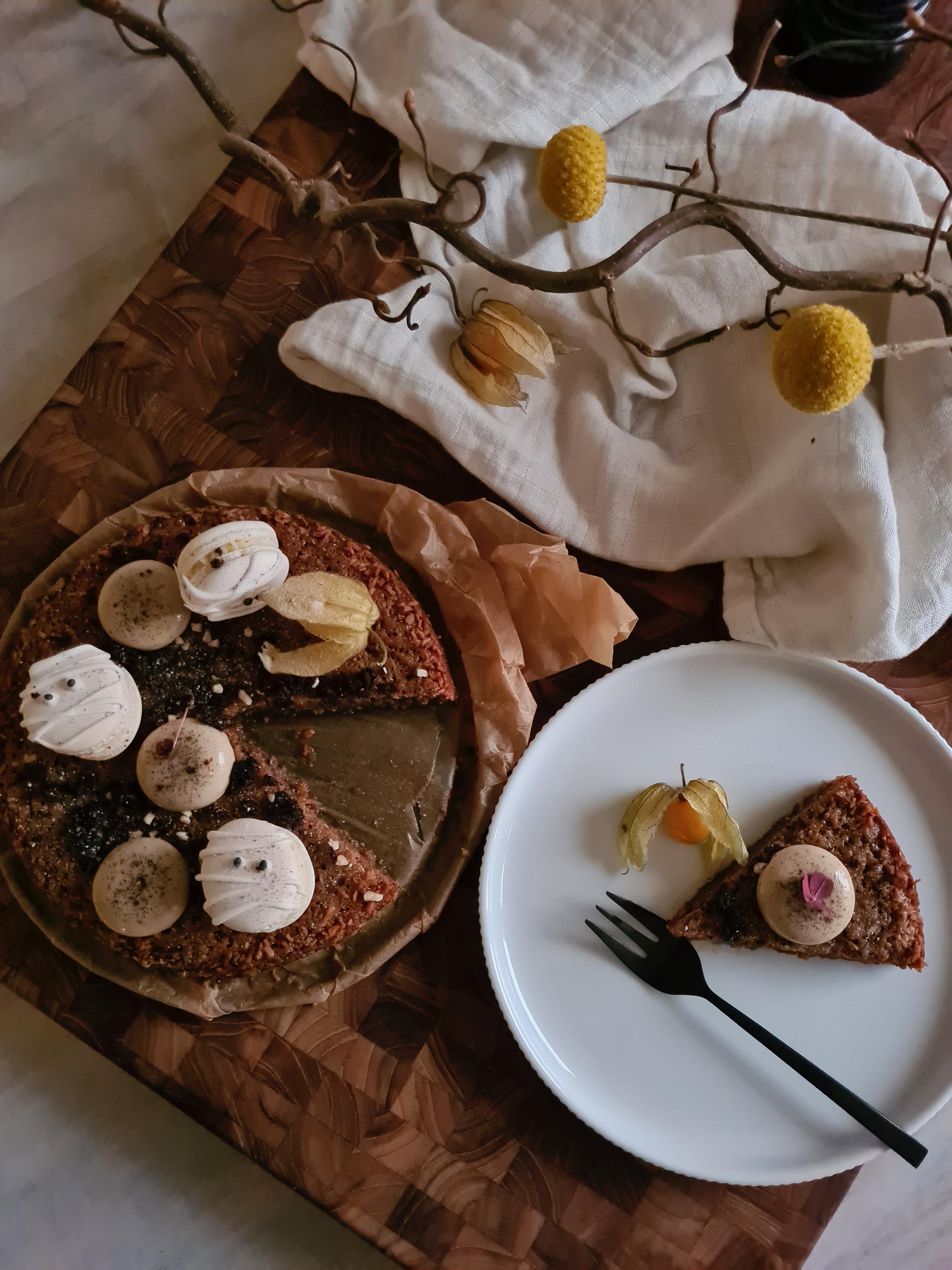 Kladdkaka som är dekorerad med macarons som ser ut som mumier