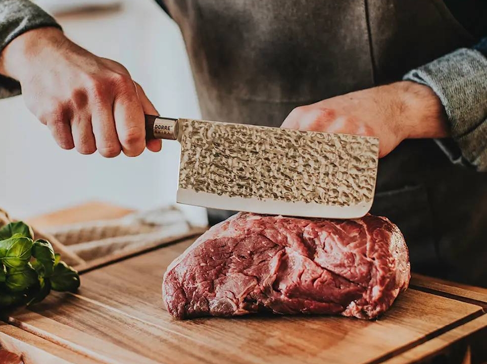 Kiinalainen keittiöveitsi jolla viipaloidaan lihaa puisella leikkuulaudalla