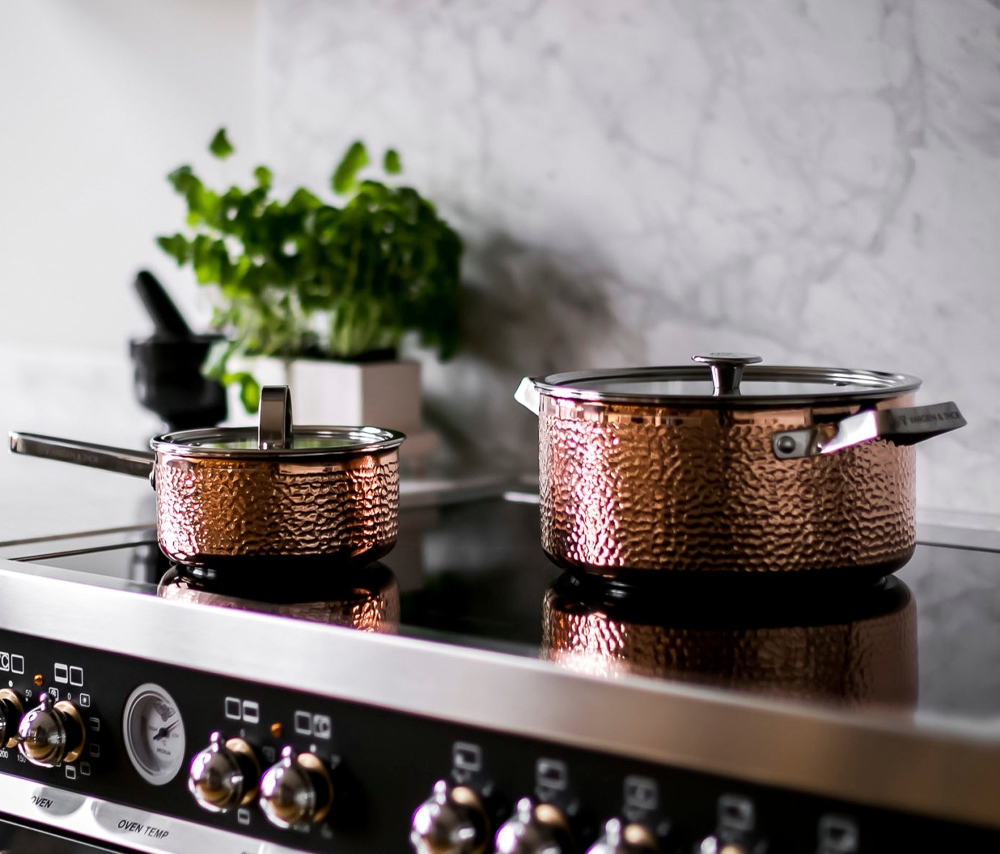 Vargen och thor kastruller på en lyxig svart spis i ett kök