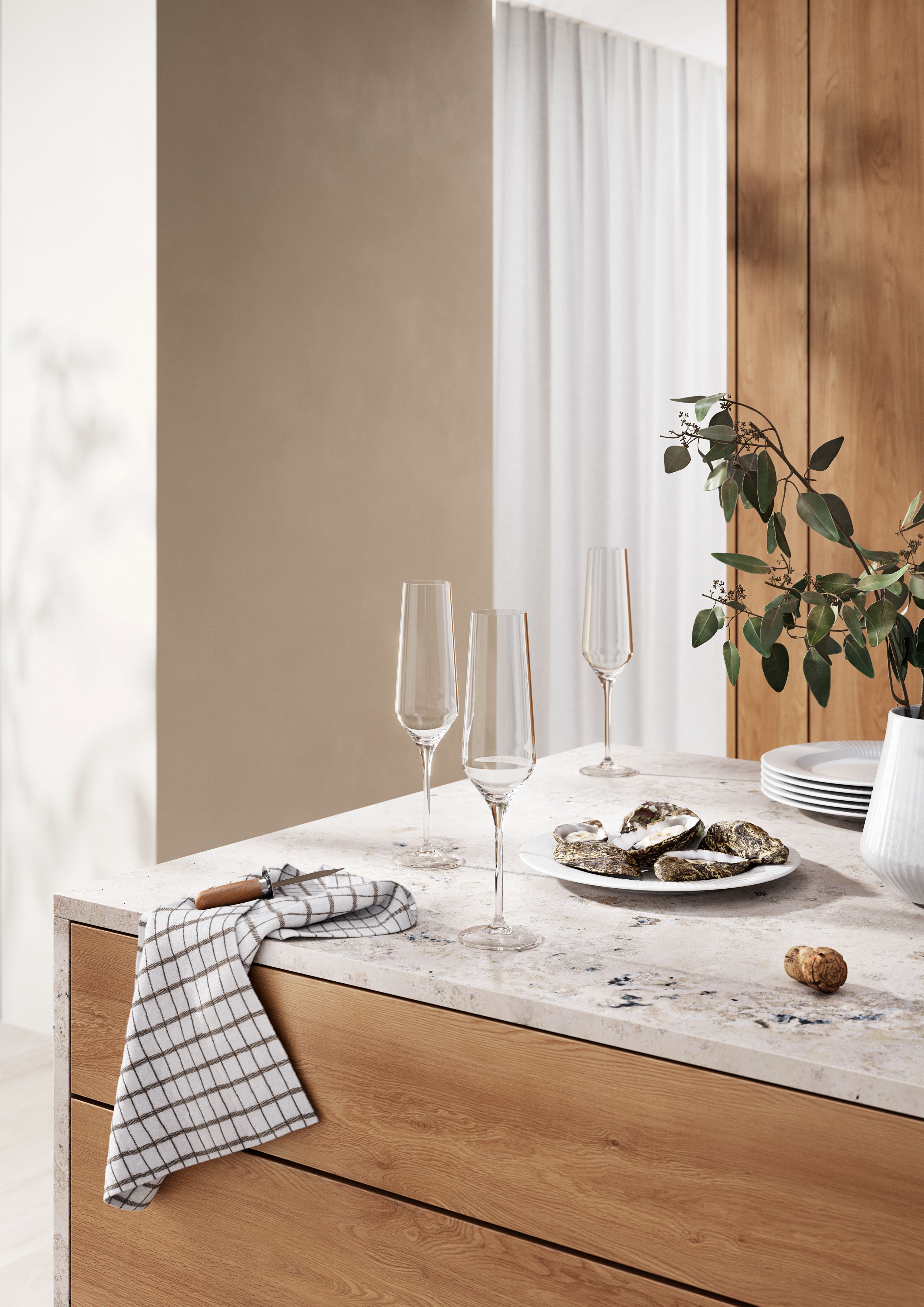 Moderni keittiön tiski, jolla on ostereita, samppanjalasillisia, ruudullinen pyyhe ja kasvi puisten kaappien yläpuolella.