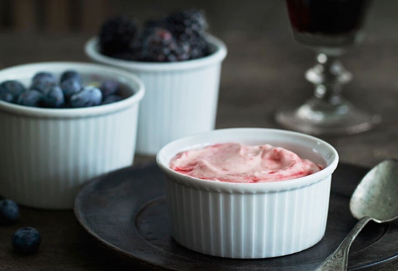 Ramekin med rose dessert och blåbär i bakgrunden 