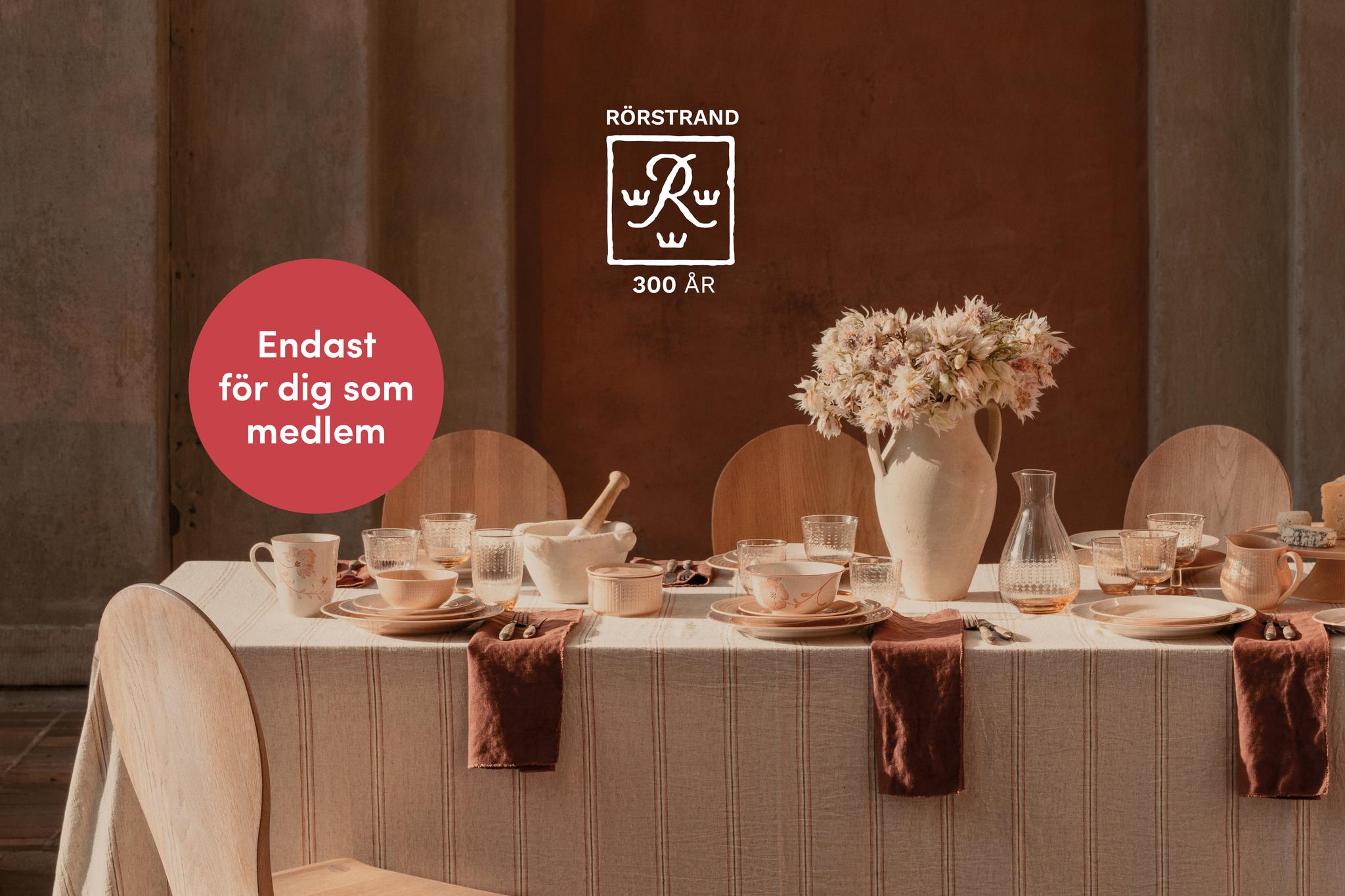 Dukat matbord med Rörstrands servis, en blomstervas och text: 'RÖRSTRAND 300 ÅR' och 'Endast för dig som medlem'.