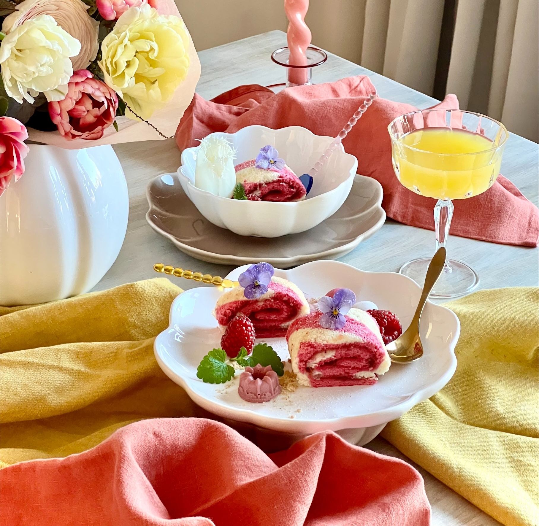 Rosa rulltårta med hallon på vit assiett