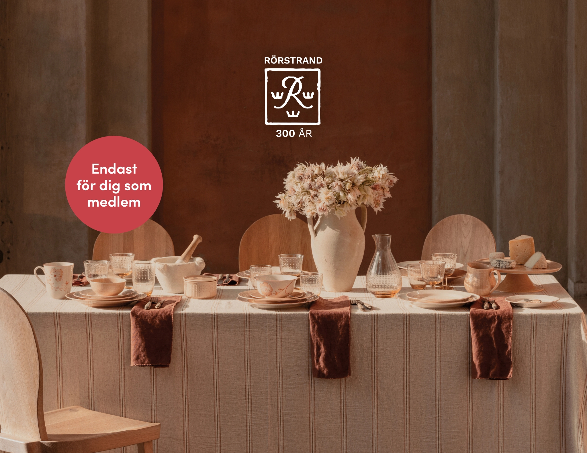 Dukat matbord med Rörstrands servis, en blomstervas och text: 'RÖRSTRAND 300 ÅR' och 'Endast för dig som medlem'.