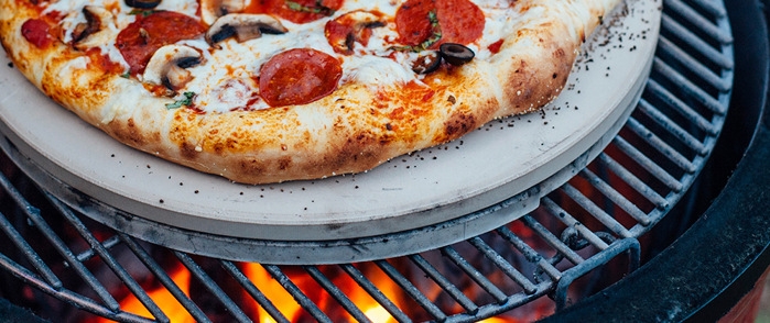 Baksten pizzasten med gräddad pizza på