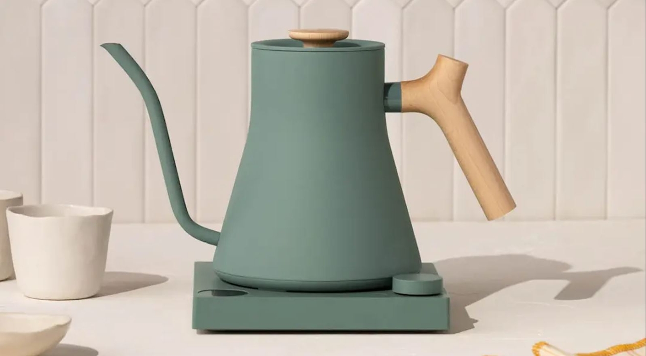 Fellow vattenkokare i grönt i ett vitt kök