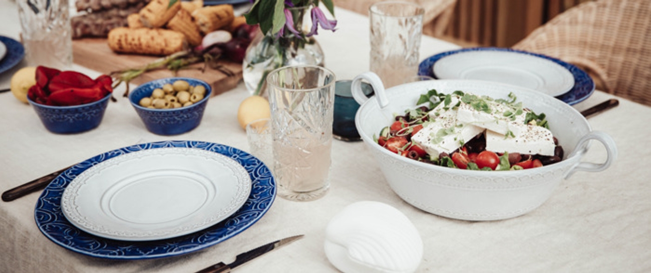 Fat og skåler på et dekket bord med hvit duk