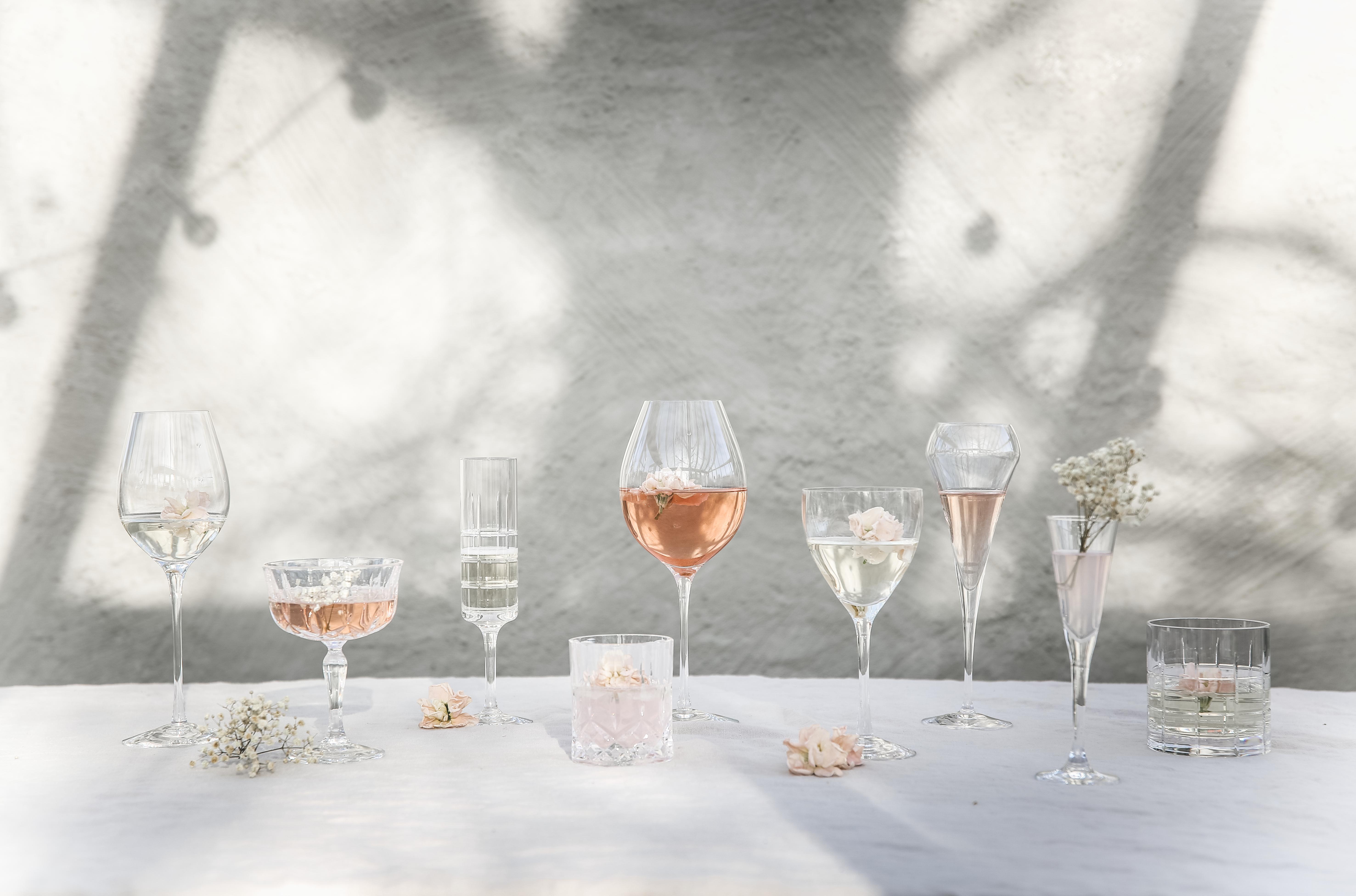 Vinglass og champagneglass på et bord med hvit duk