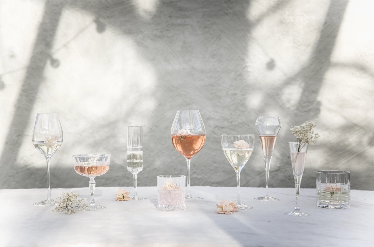 Vinglass og champagneglass på et bord med hvit duk