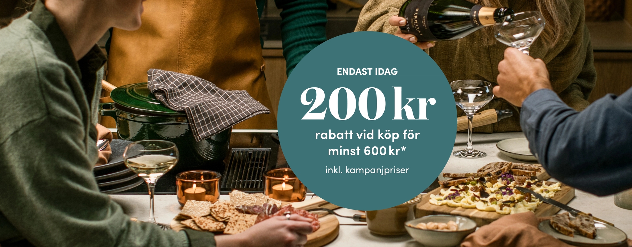Vänner samlas kring en festlig middag med vin och erbjudandet 200 kr rabatt vid köp för minst 600 kr.