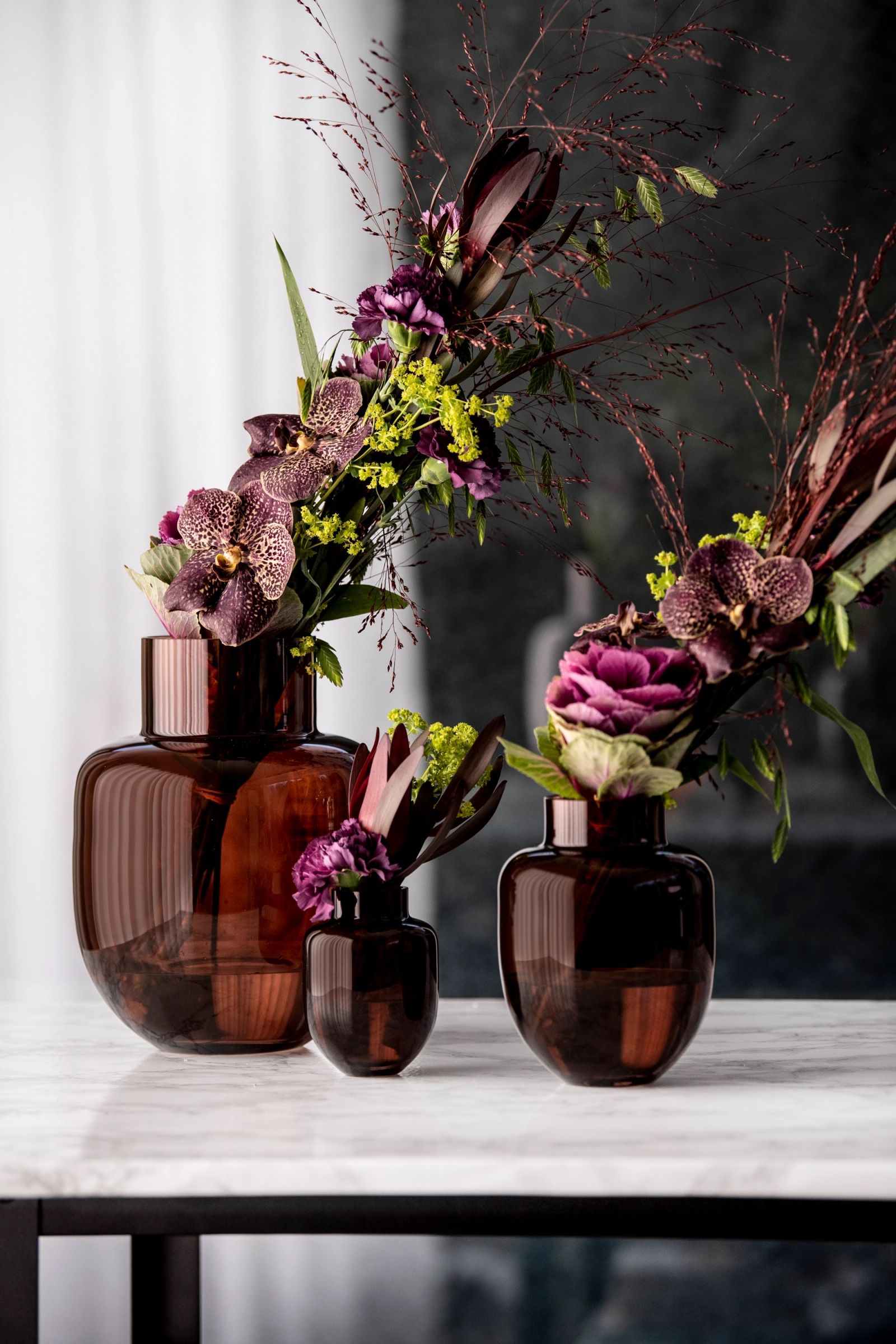 Brun vas fylld med en vacker blombukett i grönt och rosa