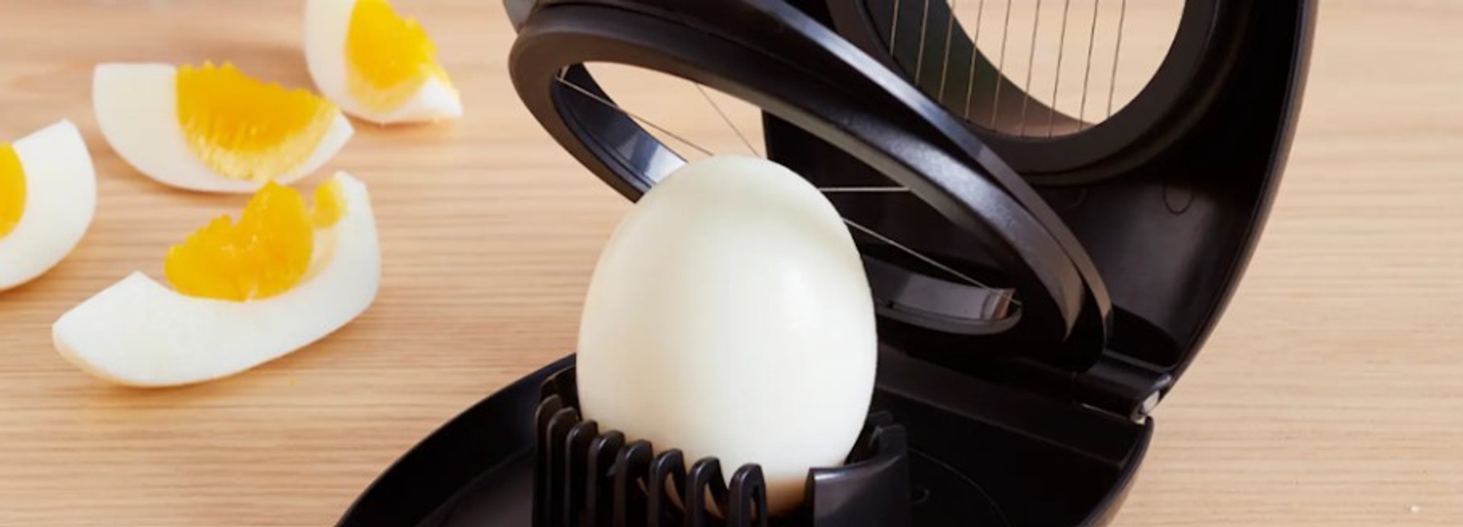 Äggskärare i vart med ägghalvor och ägg som ska delas 