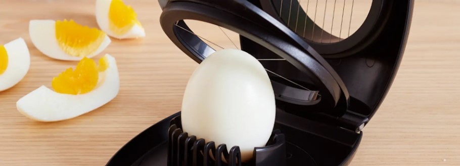 Äggskärare i vart med ägghalvor och ägg som ska delas