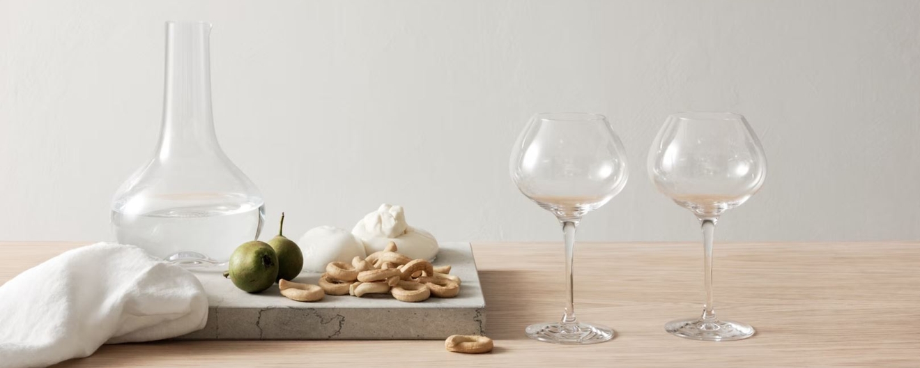 Pöydällä on kaksi viinilasia ja dekantteri.
