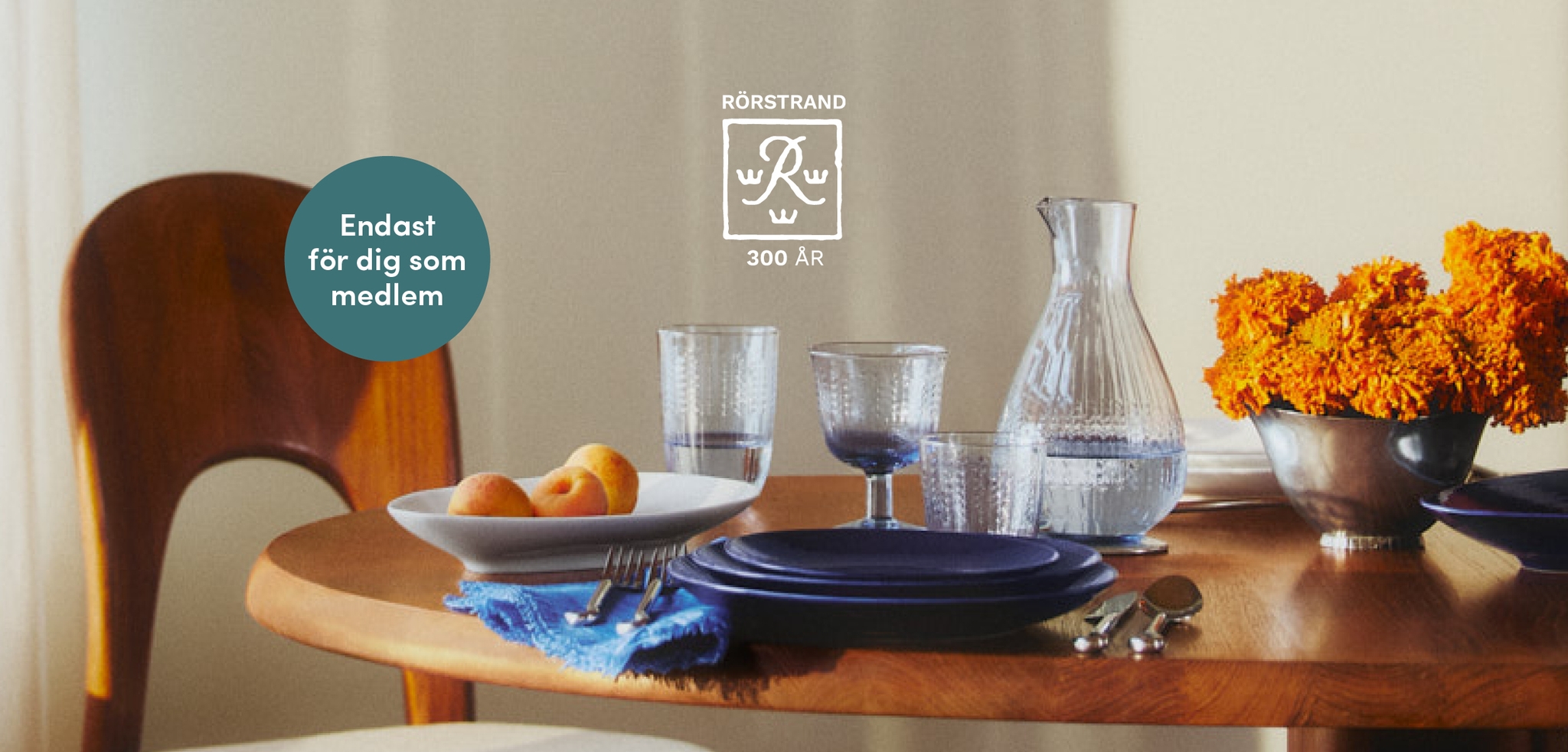 A wooden table set with Rörstrand blue and white tableware, textured glass, apricots, and orange flowers. Text overlays read: "RÖRSTRAND 300 ÅR" and "Endast för dig som medlem."
