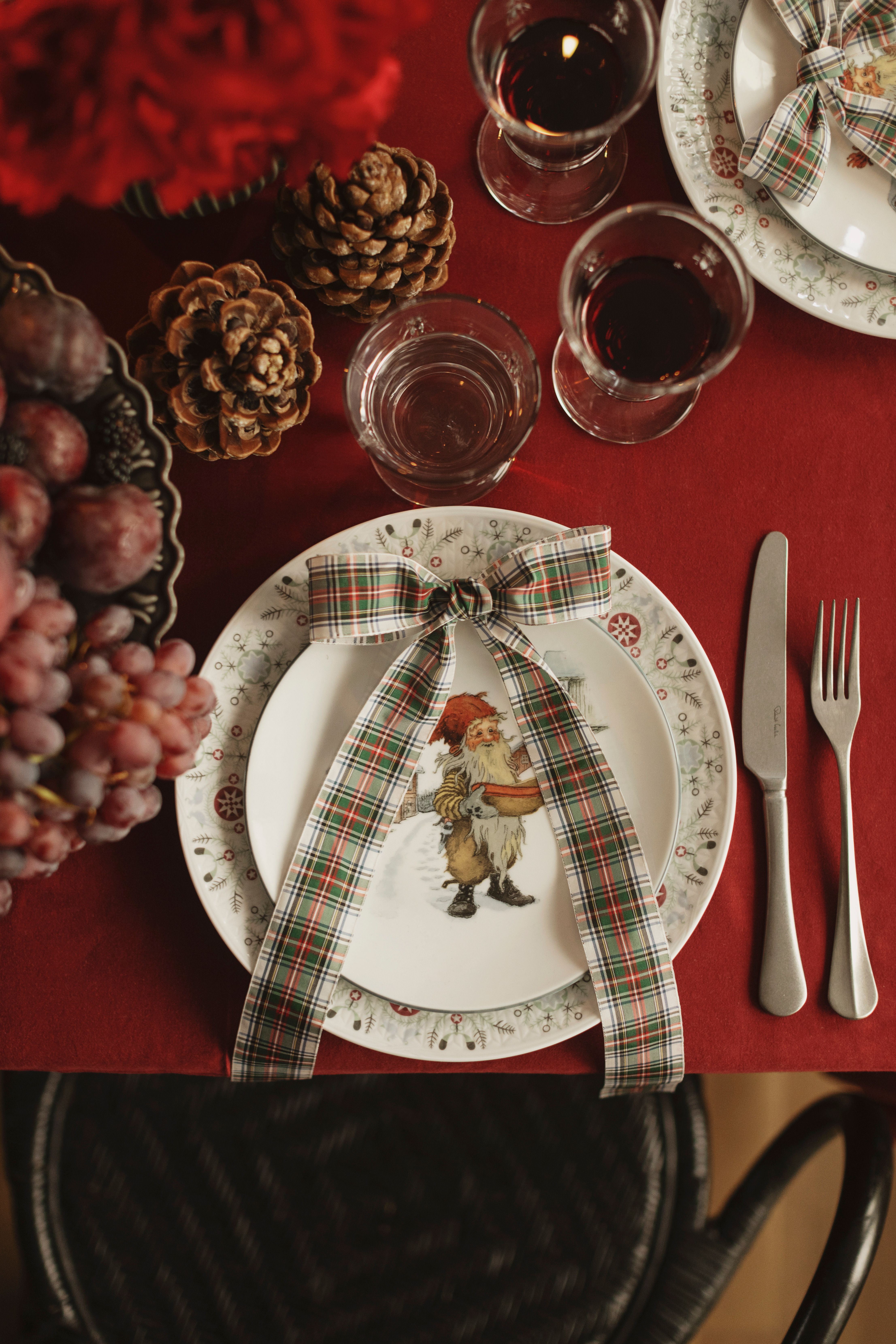 Et julebord dekket med servise med en julenisse på