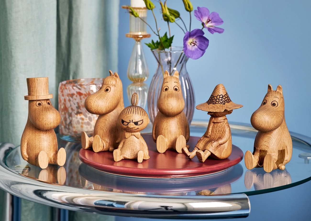 Muminfigurer i trä som sitter på ett bord