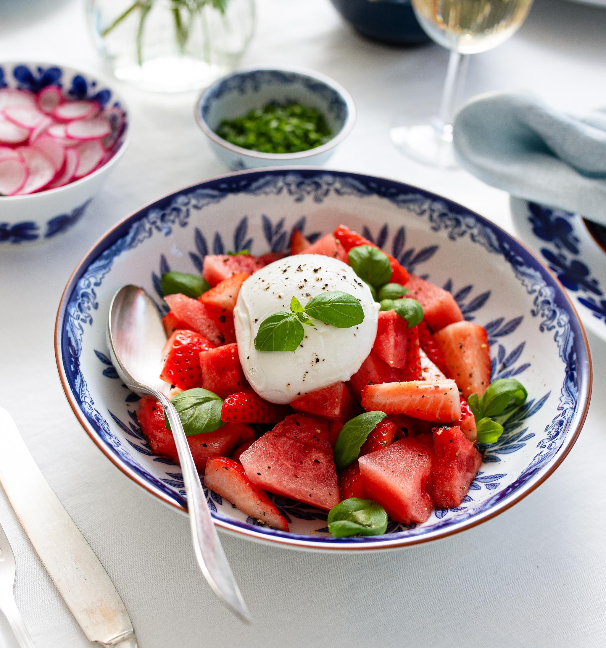 Sommarsallad med vattenmelon, jordgubbar och burrata i en blåvit serveringsskål