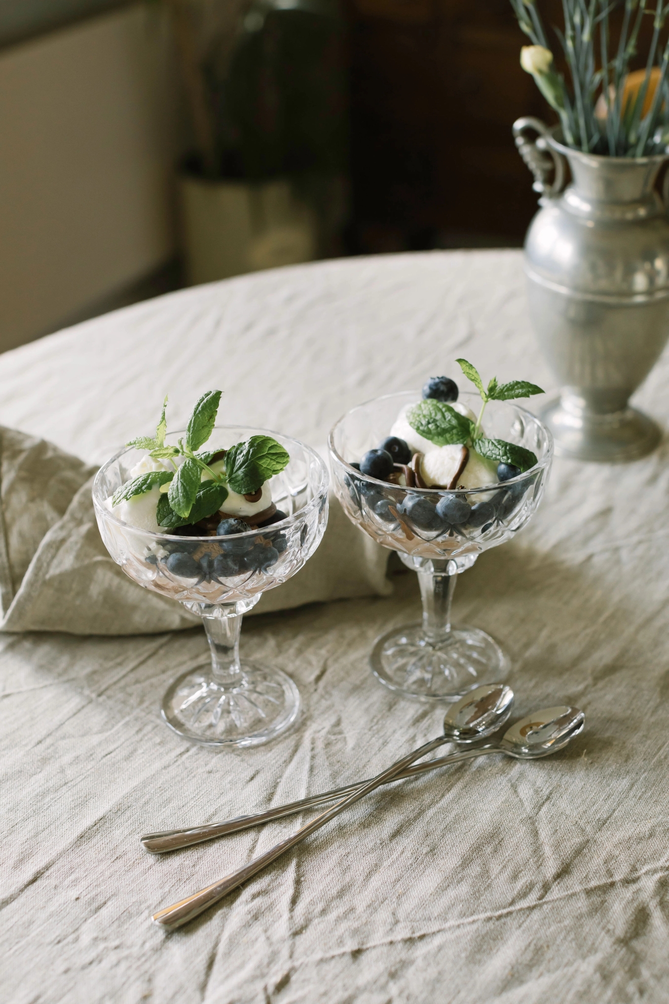 Dorre glasskålar med glasdessert och blåbär och mynta