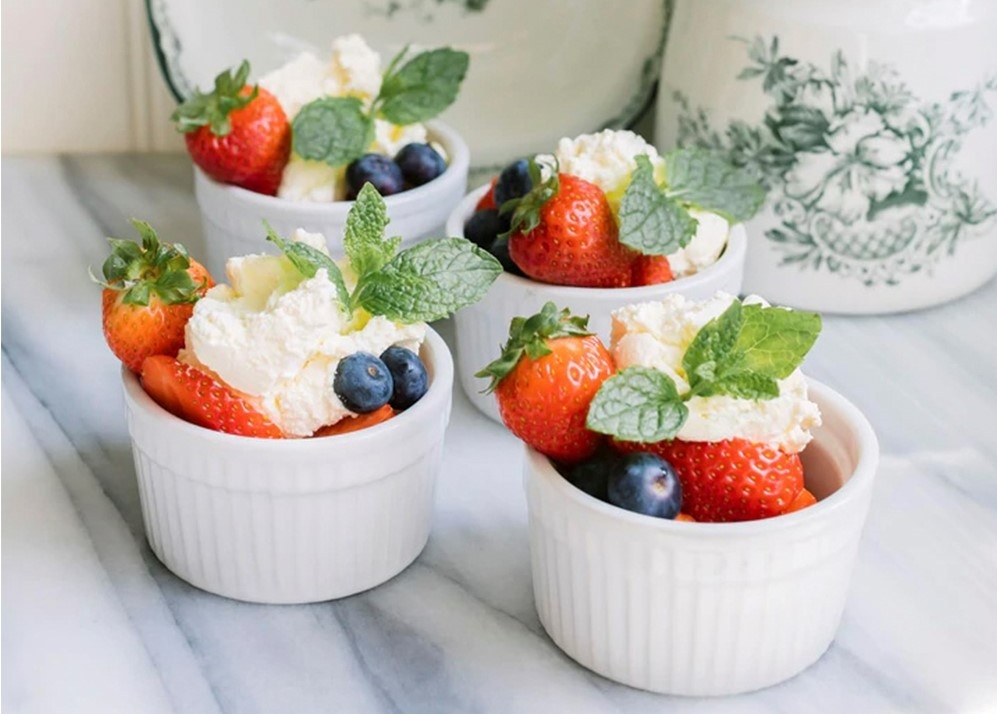 Hvit suffléform fylt med kake, bær og mynte