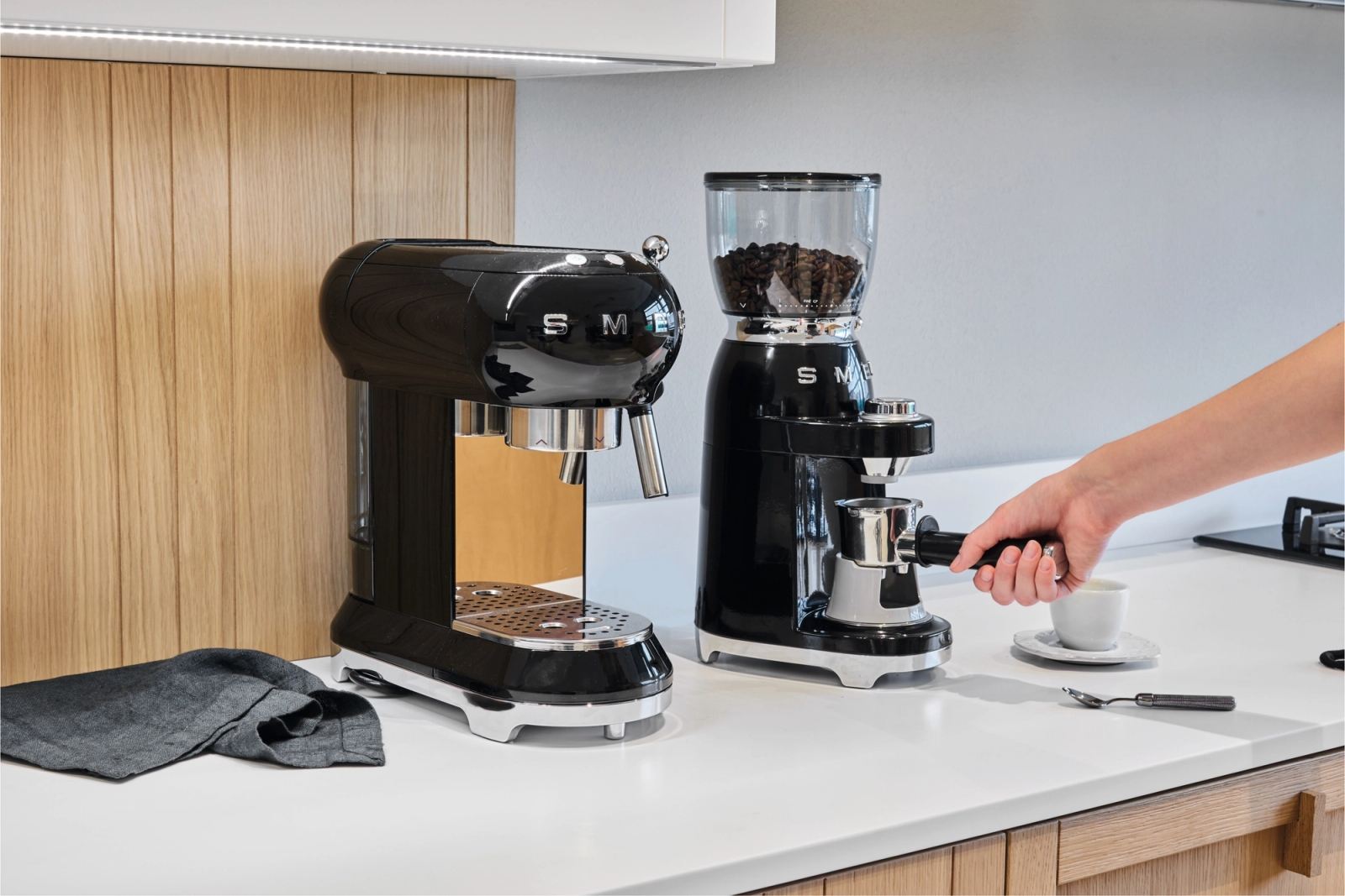 Smeg kaffekvarn i svart som maler kaffebönor på vit bänskskiva