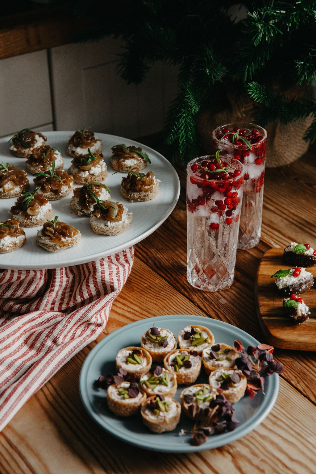 Puolukka gin & tonic korkeassa lasissa ja alkupalat lautasella
