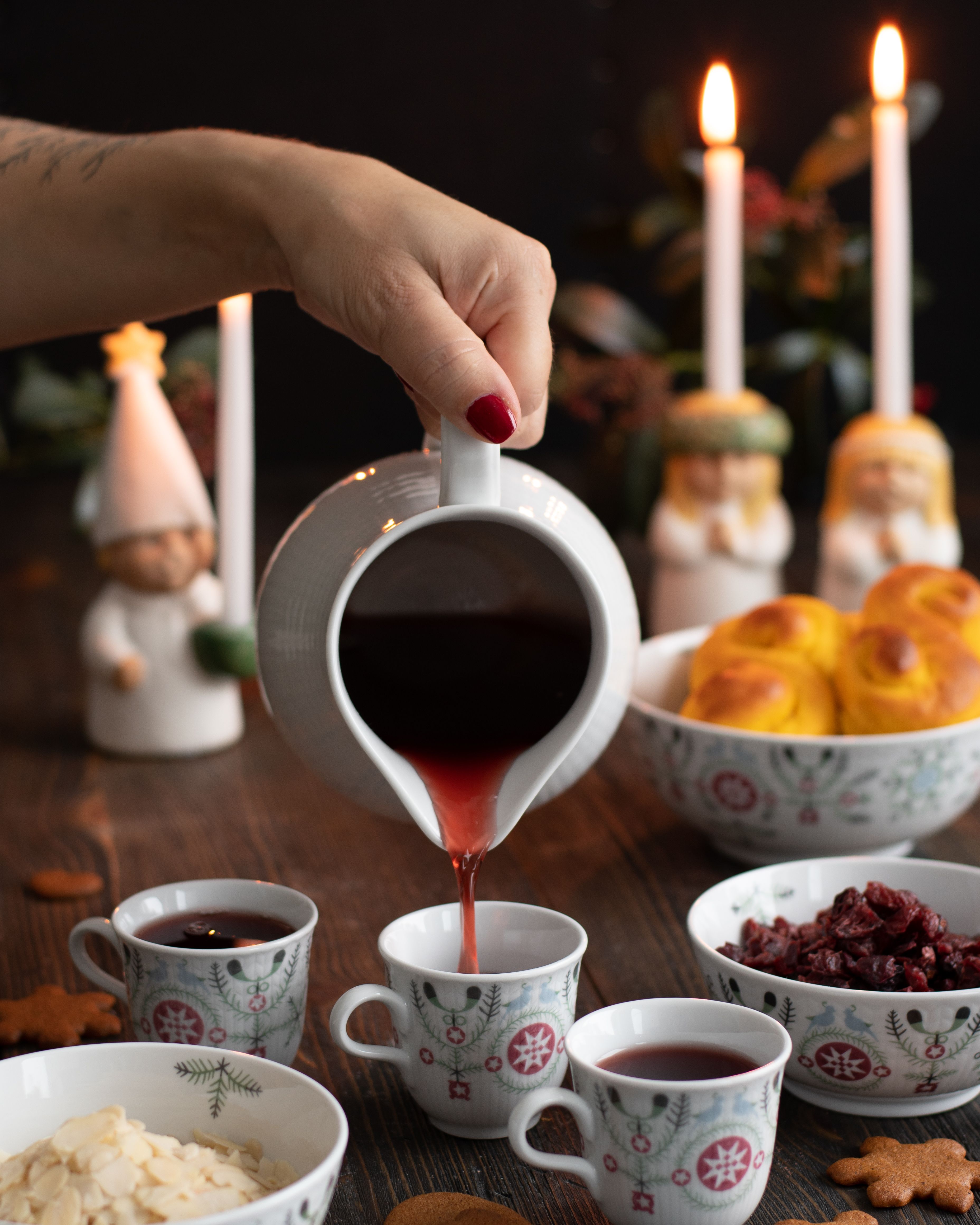 Glöggmuggar, muminglöggmuggar i glas fyllda med glögg samt fina dekorerade pepparkakor