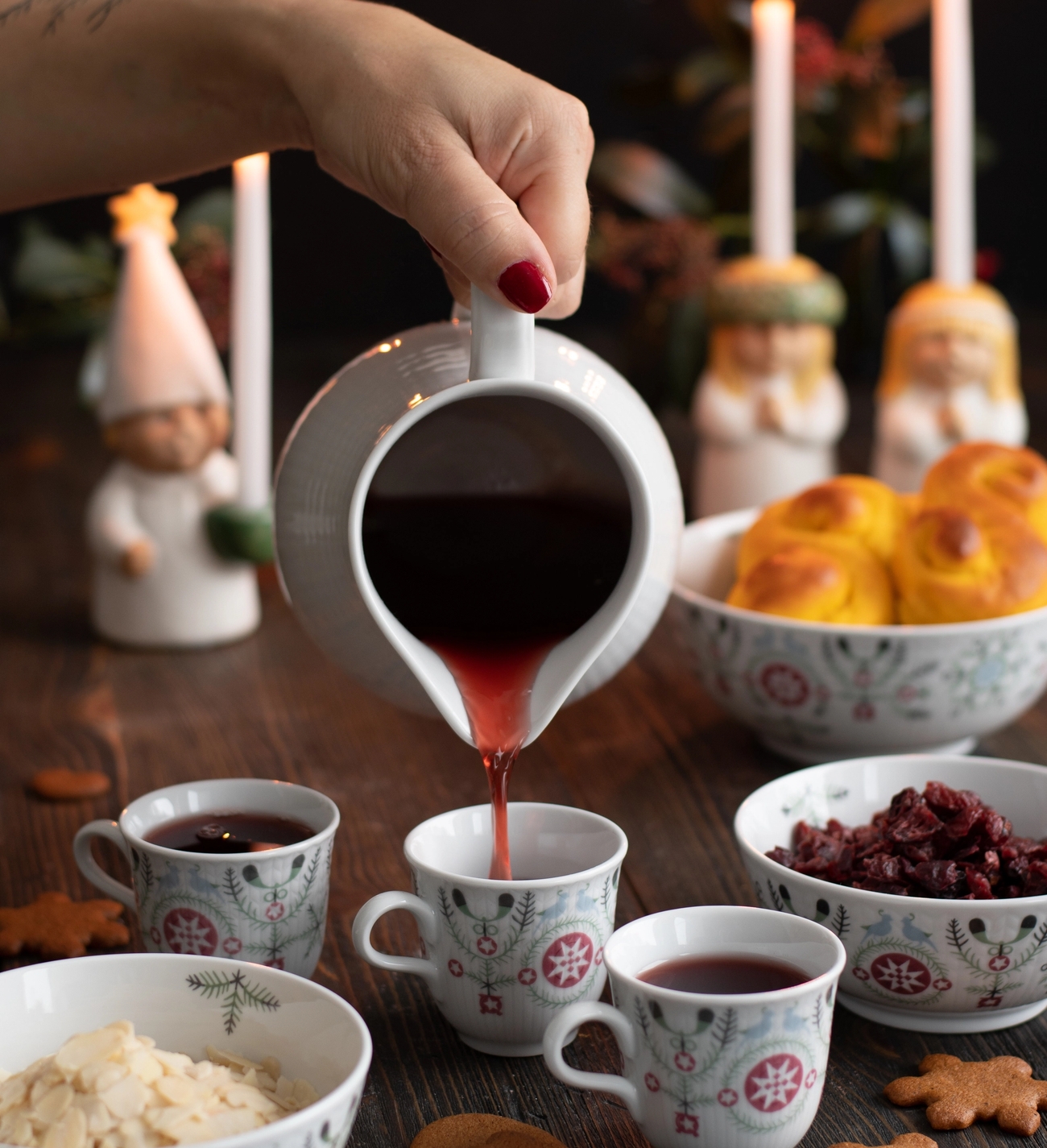 Glöggmuggar, muminglöggmuggar i glas fyllda med glögg samt fina dekorerade pepparkakor
