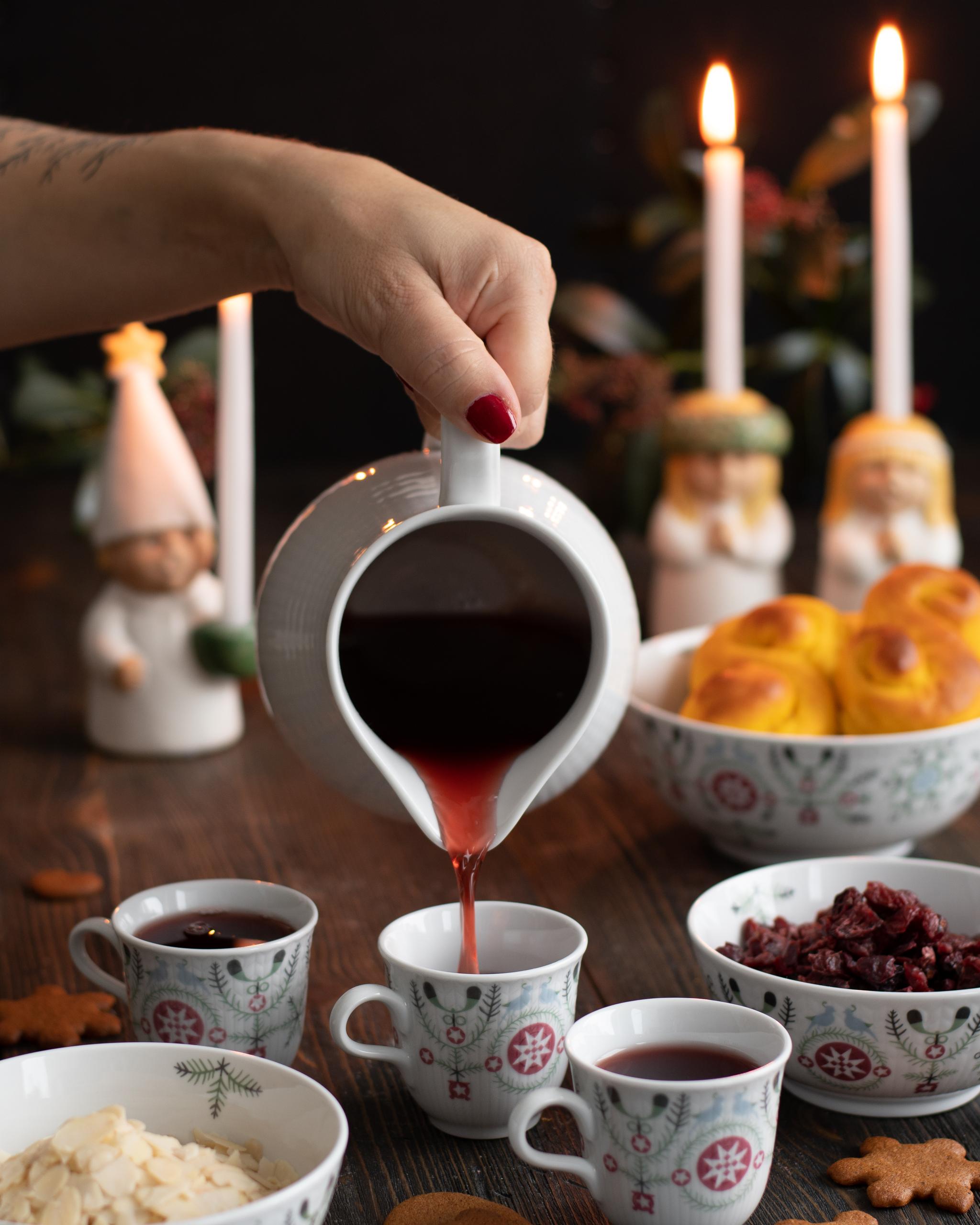 En person gäller upp glögg i koppar från Swedish Grace Winter