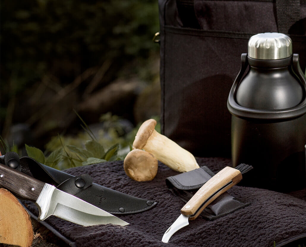 Ihana metsä, termos, mukit ja tyylikkäät sieniveitset puisilla kahvoilla