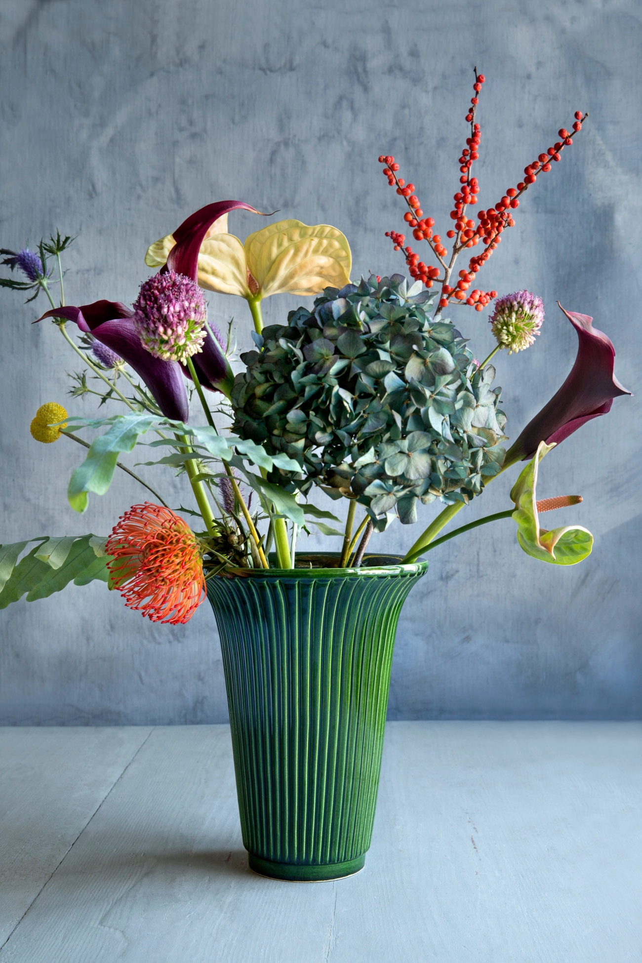 Bergs Potter grön kruka med en färgglad blombukett i