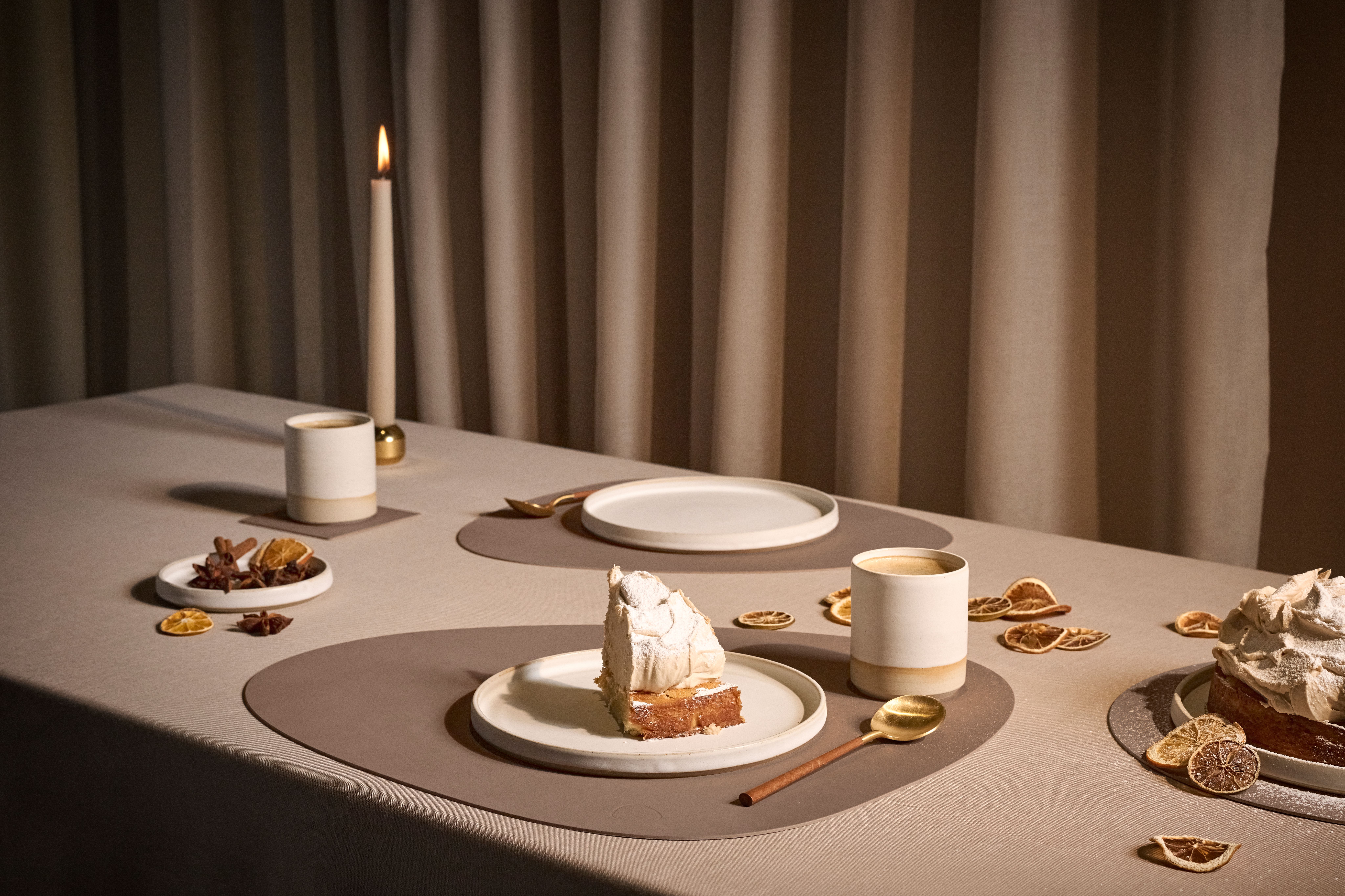 Ett bord dukat med bordstabletter och assietter med kaka på